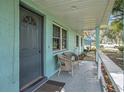 Inviting front porch with seating, a storm door, and light blue exterior at 3440 Pittman Rd, Dover, FL 33527