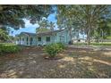 Light blue home showcasing a spacious backyard with mature trees at 3440 Pittman Rd, Dover, FL 33527