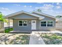 Charming home featuring updated gray paint, new windows, and inviting curb appeal with sidewalk leading to the front door at 483 32Nd N Ave, St Petersburg, FL 33704