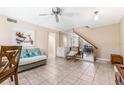 Open-concept living room, neutral paint, tile floor, ceiling fan, and mirrored wall accents at 501 E Bay Dr # 802, Largo, FL 33770