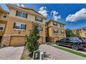 Townhome with tan stucco, brown shutters, and a brick paver driveway leading to a one-car garage at 5030 Herring Ct, New Port Richey, FL 34652