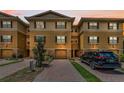 Townhome with tan stucco, brown shutters, and a paver driveway leading to a one-car garage at 5030 Herring Ct, New Port Richey, FL 34652
