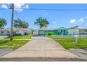 Single-story turquoise home with an American flag, carport, and white picket fence at 5107 Pine St, Seffner, FL 33584