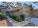Exterior view of the property featuring a paved walkway, manicured shrubbery, and a two-car garage at 5340 Cobblestone Ct, Wesley Chapel, FL 33543