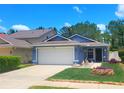 Charming single-story home with a well-maintained lawn, lush landscaping, and two car garage at 7010 Kendall Heath Way, Land O Lakes, FL 34637