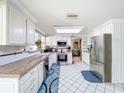 Bright kitchen featuring white cabinets, stainless steel appliances, and tiled floors at 7111 Lawnview Ct, Tampa, FL 33615