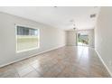 Bright and airy living room with tile flooring and sliding glass doors leading to the backyard at 7211 Ozello Trail Ave, Sun City Center, FL 33573