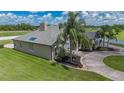 A view of the side of the home highlighting the roof, landscaping, and circular driveway at 7301 Loghouse Rd, Plant City, FL 33565