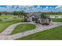 An elegant home with a circular driveway and lush lawns, framed by mature trees and a pond at 7301 Loghouse Rd, Plant City, FL 33565