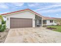 Lovely single-story house with a brown garage door, red roof tiles, and a well-maintained front yard at 734 Flamingo Dr, Apollo Beach, FL 33572