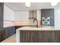 Modern kitchen featuring stainless steel appliances, a central island, and stylish dark wood cabinets at 777 3Rd N Ave # 1607, St Petersburg, FL 33701