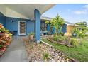 Close-up of the inviting front porch with colorful landscaping and attractive entryway at 7810 Flintlock Dr, Port Richey, FL 34668