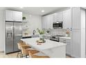 Bright, modern kitchen with stainless steel appliances, island with seating, and white cabinets at 8485 Pelican Ln, Seminole, FL 33777