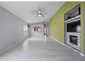 Spacious living room featuring modern flooring, neutral paint, and a stylish fireplace entertainment center at 8526 Quarter Horse Dr, Riverview, FL 33578