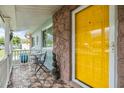 Inviting front porch with a yellow door and cozy seating area at 9056 108Th Ave, Seminole, FL 33777