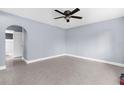 Spacious bedroom with arched doorway, ceiling fan, and neutral tile flooring throughout at 9310 N 12Th St, Tampa, FL 33612