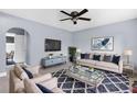 Bright living room with modern decor, plush seating, stylish rug, and a contemporary ceiling fan at 9310 N 12Th St, Tampa, FL 33612