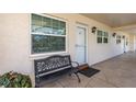 Exterior of the unit showcasing a bench seat, the front door, an exterior light fixture, and large window at 940 Virginia St # 303, Dunedin, FL 34698