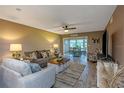 Cozy living room with wood flooring, a ceiling fan, a comfortable sofa, and a view into the dining area at 940 Virginia St # 303, Dunedin, FL 34698
