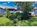Exterior shot of a two story condo with a bench, grill, and lush landscaping at 10265 Gandy N Blvd # 1409, St Petersburg, FL 33702