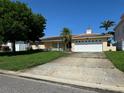 Charming single-story home with a two-car garage, well-maintained lawn, and mature trees at 1135 81St S St, St Petersburg, FL 33707