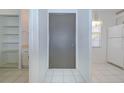 Hallway with a large gray closet door, tile flooring, and access to the kitchen at 11511 113Th St # 33D, Largo, FL 33778