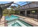 Backyard pool with screened enclosure, adjacent to spa with water feature and outdoor bar at 12415 Hitching St, Odessa, FL 33556