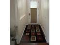 Hallway with decorative rug leading to bright door with covered window at 1247 Gentilly Ln, Wesley Chapel, FL 33544