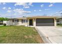 Charming single-story home with a well-manicured lawn and an attached two-car garage at 13727 Gene Rossi Ave, Hudson, FL 34667