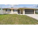Charming single-story home with a well-manicured lawn and an attached two-car garage at 13727 Gene Rossi Ave, Hudson, FL 34667