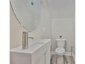 Modern half bath with a vessel sink, round mirror, and sleek fixtures on the first floor at 1410 E Curtis St # 2, Tampa, FL 33603
