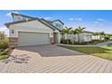 Charming home with a brick driveway, two-car garage, and palm trees in the front yard at 16423 Sapphire Point Dr, Lakewood Ranch, FL 34211