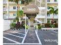 Inviting building entrance with covered walkway, lush landscaping, and dedicated parking spots at 18650 Gulf Blvd # 314, Indian Shores, FL 33785