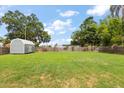 Spacious backyard with lush green grass, a shed, and a privacy fence, perfect for outdoor activities at 2306 Cheryl Rd, Largo, FL 33771