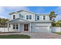 Charming two-story home with a red door, a gray roof and light blue exterior walls at 2700 Beach S Blvd, Gulfport, FL 33707