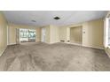 Spacious living room with neutral carpet and a view of the screened-in pool area at 3150 San Jose St, Clearwater, FL 33759