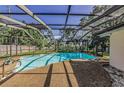 Large screened-in pool with sunny lounging area surrounded by mature trees at 3150 San Jose St, Clearwater, FL 33759