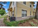 Charming tan condo with well-manicured landscaping and visible unit number, featuring an installed air conditioning unit at 3455 Castle Stone Ct, Valrico, FL 33594
