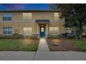 Charming two-story condo featuring a stucco facade, a blue front door, and a well-maintained landscaped yard at 3455 Castle Stone Ct, Valrico, FL 33594