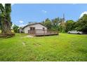 Exterior view of the home from the backyard showing green lawn and wood deck at 37732 Cecil Ln, Zephyrhills, FL 33542