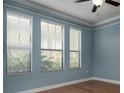 Bright bedroom with three large windows, wood laminate floors, and light blue walls, creating a serene atmosphere at 4146 Bexley Village Dr, Land O Lakes, FL 34638