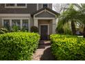 Inviting home entrance with lush green bushes leading to the front door and showcasing the house number at 4146 Bexley Village Dr, Land O Lakes, FL 34638