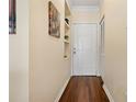 Hallway with hardwood floors, a white door, neutral-toned walls, and built-in shelves at 4207 S Dale Mabry Hwy # 8304, Tampa, FL 33611