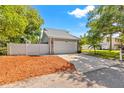 Attached two-car garage featuring stone accents, a white door, and a spacious driveway at 428 Klosterman W Rd, Palm Harbor, FL 34683
