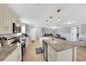Open-concept kitchen with an island and modern appliances next to open living and dining area at 5044 17Th N St, St Petersburg, FL 33714
