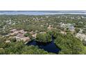 Overhead drone shot of property and the surrounding community including pond and trees at 506 Duxbury Ct # A, Safety Harbor, FL 34695
