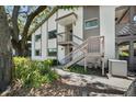 Exterior view of condominium building with staircase and mature landscaping at 506 Duxbury Ct # A, Safety Harbor, FL 34695
