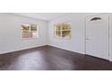 Bright living room features hardwood floors, white walls, and natural light from two windows flanking the front door at 5221 4Th N Ave, St Petersburg, FL 33710