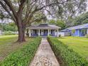 Inviting single-story home with a lovely walkway, manicured hedges, and a covered front porch at 606 N Merrin St, Plant City, FL 33563