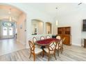 Elegant dining room featuring a wood table, arched doorways, wood-look flooring, and decorative lighting at 6331 Voyagers Pl, Apollo Beach, FL 33572
